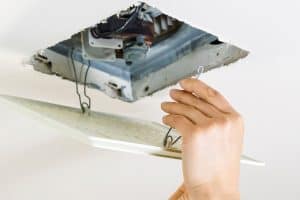 person installing bathroom fan