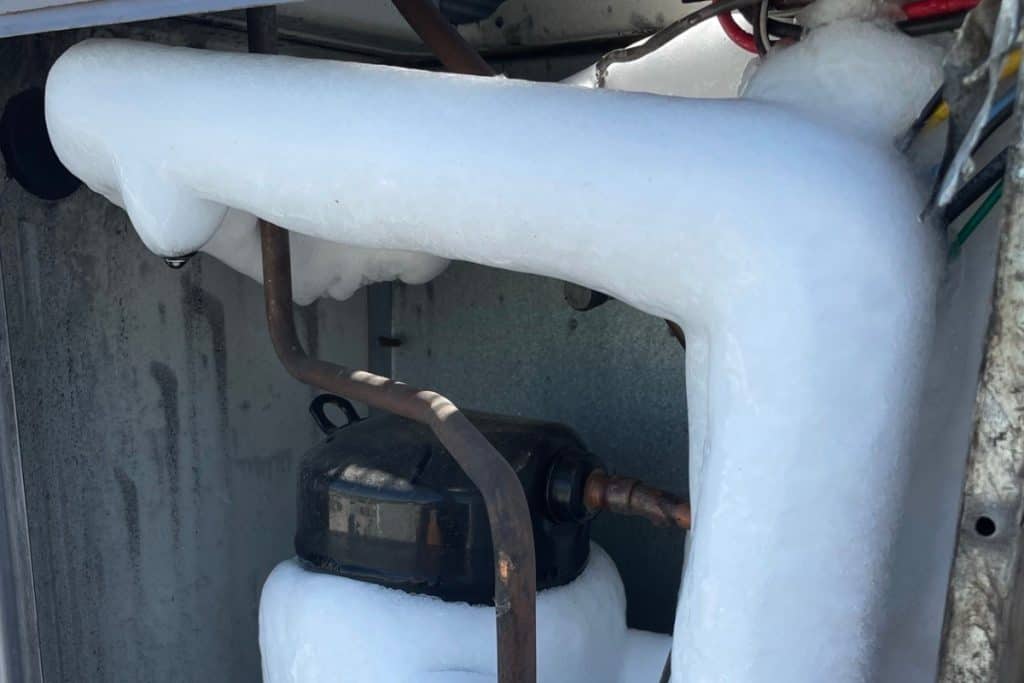 4 Causes of Your AC Freezing Up (And How To Fix It) 3 air conditioning unit covered in layer of ice